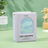 A square, light purple photo card binder labeled The Archive with an arched window showing a soft blue landscape.