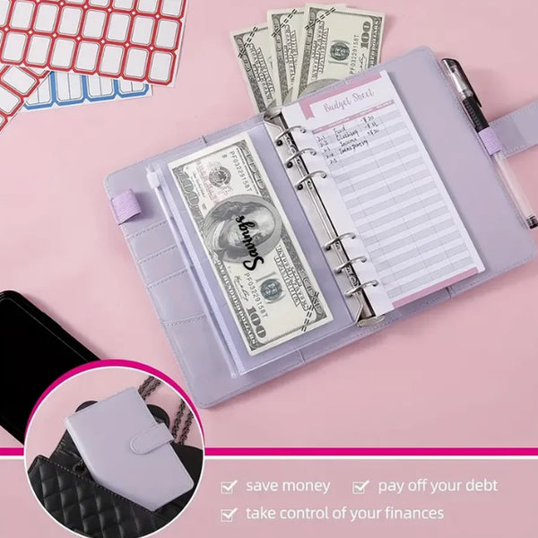 A purple leather budget binder open to show cash pockets and a handwritten sheet on a pink background.