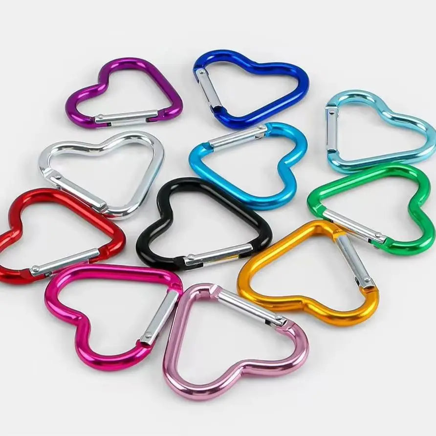 A collection of five colorful heart-shaped spring clasps and carabiner keychains in various colors like purple, blue, silver,