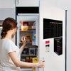 A woman looks into a refrigerator with a magnetic planning calendar set displayed on the door.