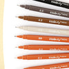 A collection of black and brown needle pen fineliner pens with various tip sizes shown on a white background.