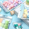 Assortment of colorful sealing bags filled with various colored wax melts and small decorative items.