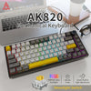 A black mechanical keyboard with RGB backlight and a yellow keycap is shown next to a laptop.