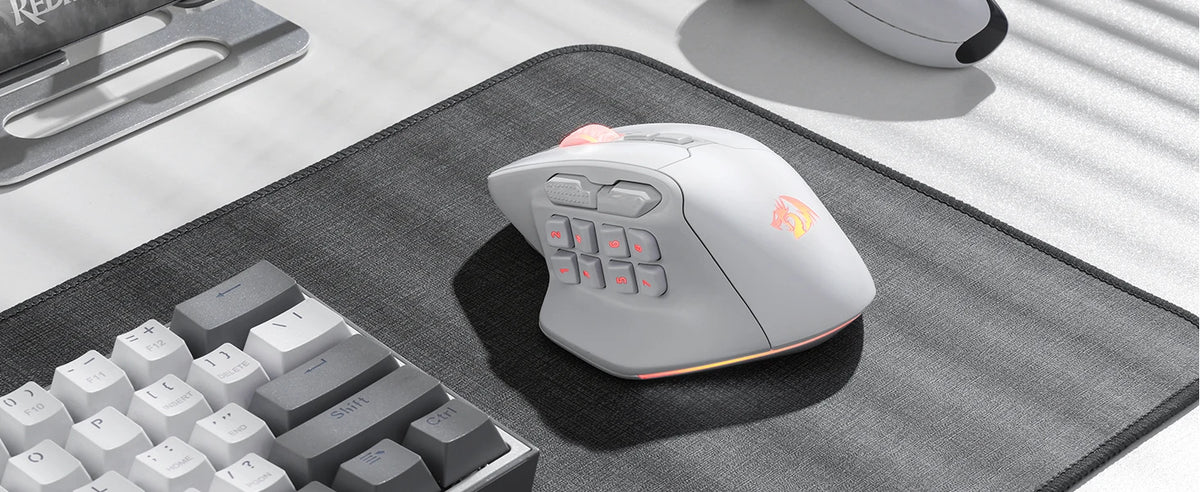 A wireless MMO gaming mouse with programmable buttons and RGB lighting resting on a gray mousepad.