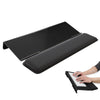 A black ergonomic acrylic keyboard wrist rest stand shown next to a hand typing on a laptop.