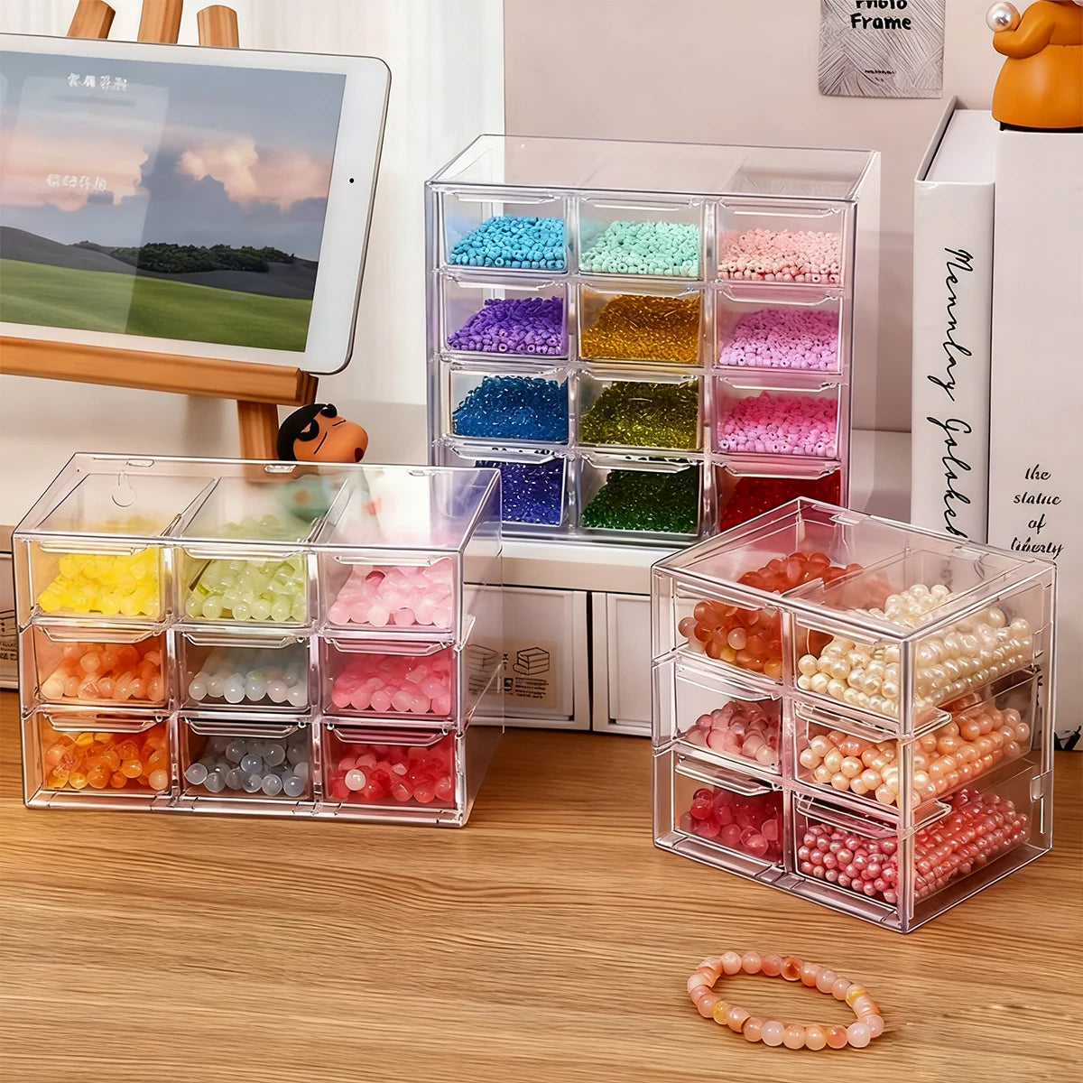 Clear acrylic storage boxes filled with various colored beads and stones for jewelry making or crafting