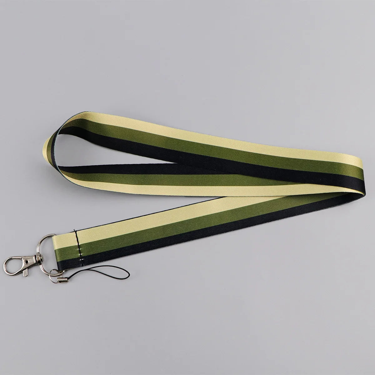 A black and olive green striped vintage cassette tape lanyard with a metal clip.