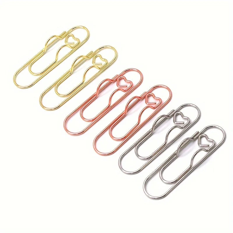 A collection of mixed color heart-shaped metal pen clips in gold and rose gold tones.