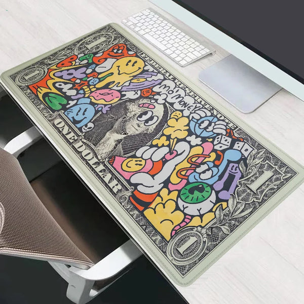 A black and colorful extended gaming desk mat featuring cartoon characters and dollar signs placed on a white wooden desk.