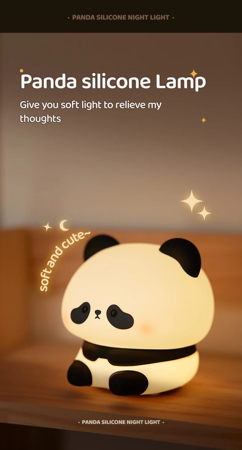 A white panda silicone night light with black accents sitting on a wooden surface.
