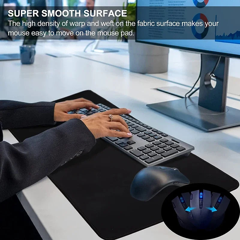 A hand rests on a black desk mat mouse pad with a computer mouse nearby.