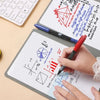A hand is writing on a whiteboard with various mathematical formulas and diagrams, next to a laptop and a pen.