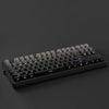 A black mechanical keyboard with gradient gray double shot PBT keycaps and side printing shown from a top-down angle.