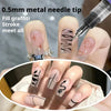 Gros plan d'une main appliquant de l'encre pour graffiti à pointe de aiguille métallique sur les ongles pour le nail art