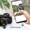 يد تمسك بهاتف ذكي يعرض صورًا، بجوار كاميرا ومحول USB OTG.