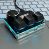 A close-up of a SayoDevice USB-C magnetic rapid trigger keyboard switch module resting on a gray laptop keyboard.
