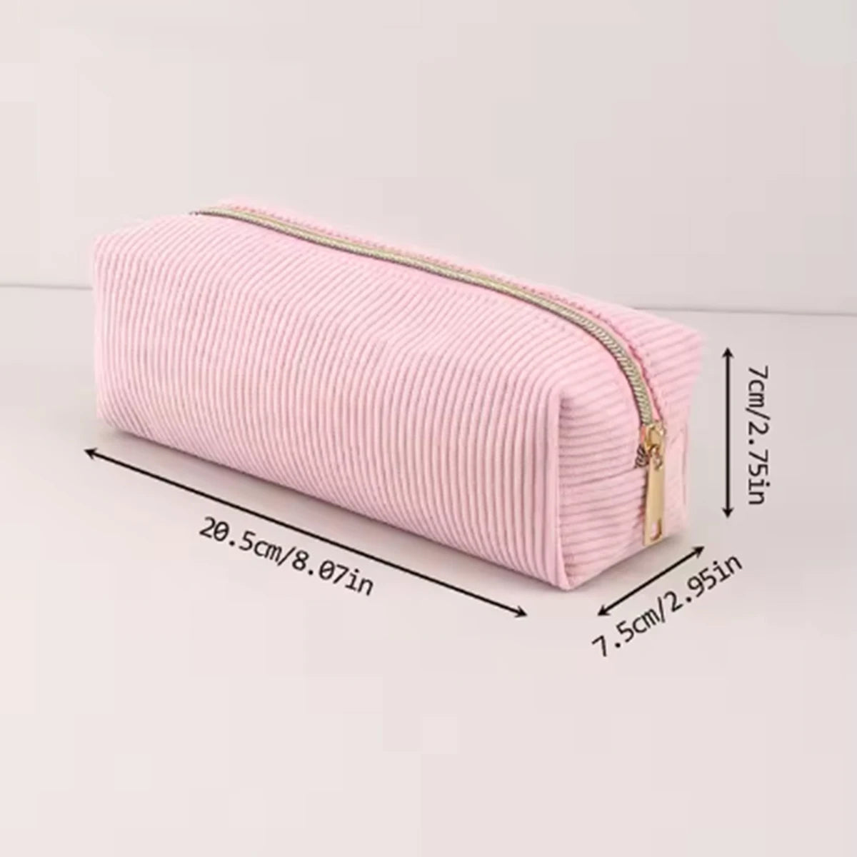 A pink ribbed pencil case with a gold zipper shown lying flat.
