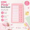 A pink blank board with sliding slots for writing tasks and tracking habits.