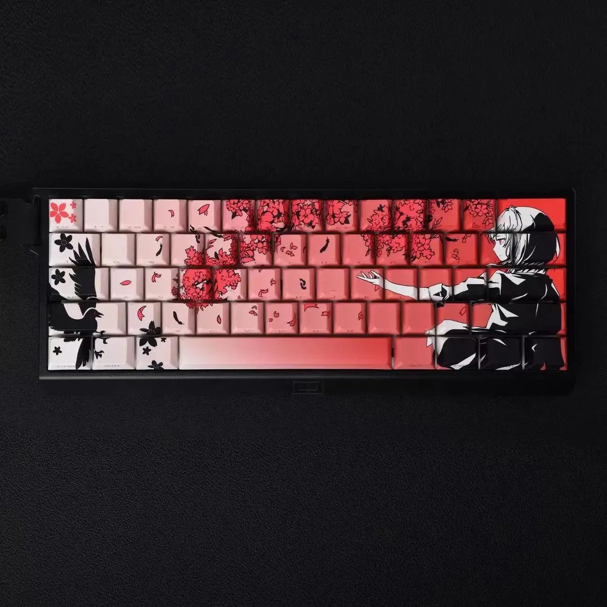 A close-up of mechanical keycaps featuring a raven and sakura theme with red and white accents.