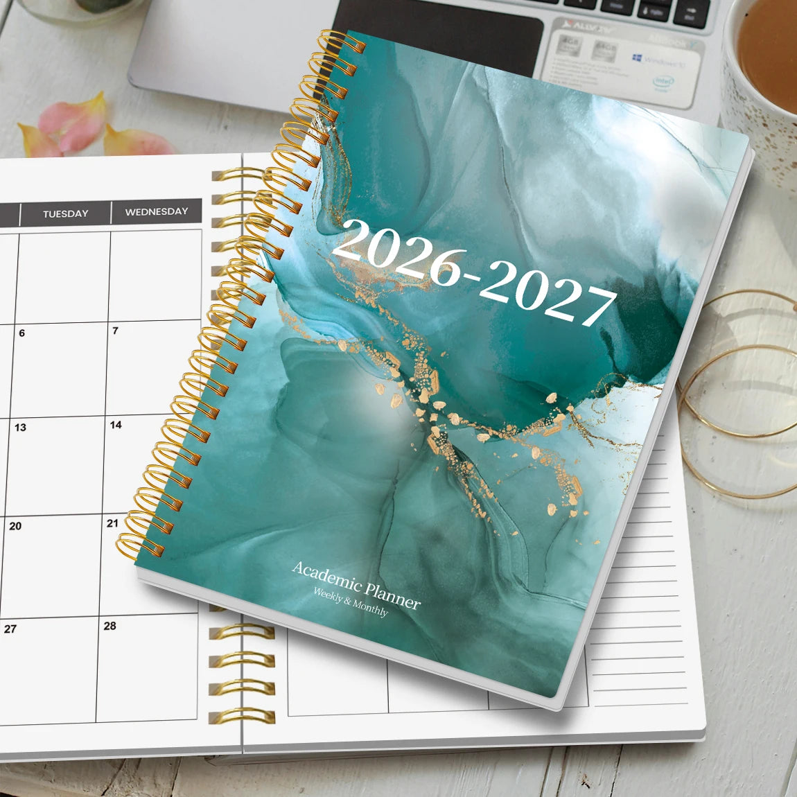 A spiral-bound academic planner showing the cover for 2026-2027 with a teal watercolor design and gold accents.