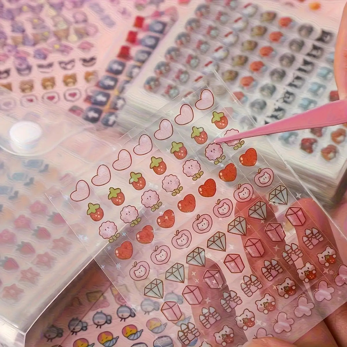 A hand holds a clear sticker sheet featuring various cute patterns like hearts, strawberries, and geometric shapes for journa