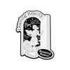 Black and white enamel lapel pin featuring an arched silhouette with text reading Leaving Reality Bye Entering Fiction