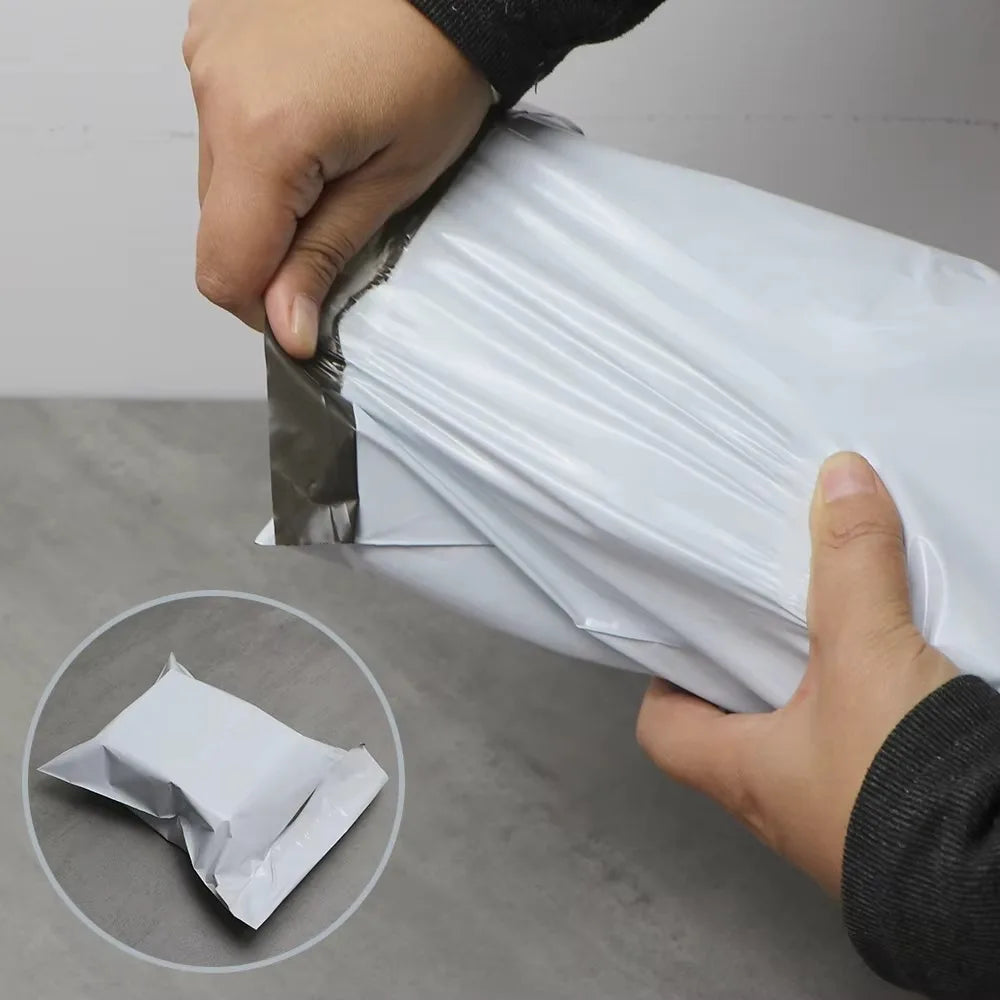 A hand is holding a white dustproof mailing bag, demonstrating its sealing capability.