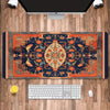 A vintage Persian rug design mouse pad featuring deep blue, orange, and gold patterns placed on a wooden desk with a computer