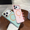 A pink phone case with an orange circular design is displayed next to a light blue version on a wooden table.