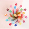 A collection of acrylic paint markers in various colors and tips arranged diagonally against a light background.