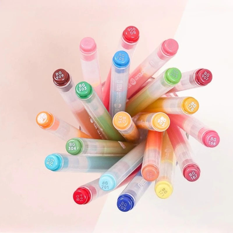 A collection of acrylic paint markers in various colors and tips arranged diagonally against a light background.