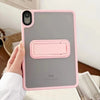 A hand holds a pink protective case for an iPad, showing the device's back panel.