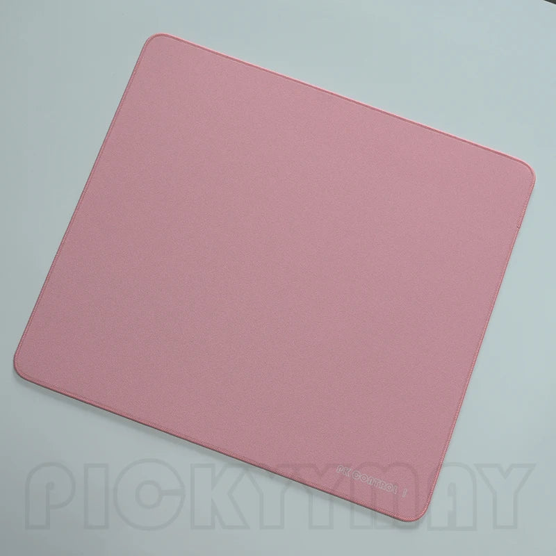 A pink professional gaming mouse pad desk mat lying flat on a light surface.
