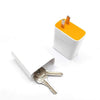 A white storage box with an orange top and a metal key is shown on a white background.