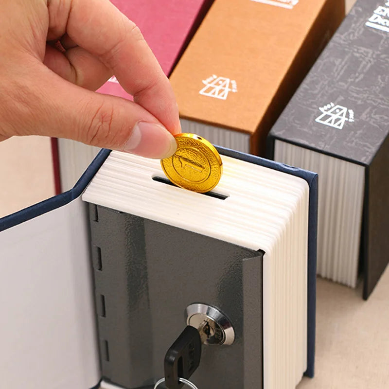 A hand inserts a gold coin into the slot of a classic book-shaped piggy bank with a lock and key.