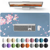 A large gray PU leather desk mat featuring a laptop and keyboard, surrounded by scattered pink petals and various colored cir
