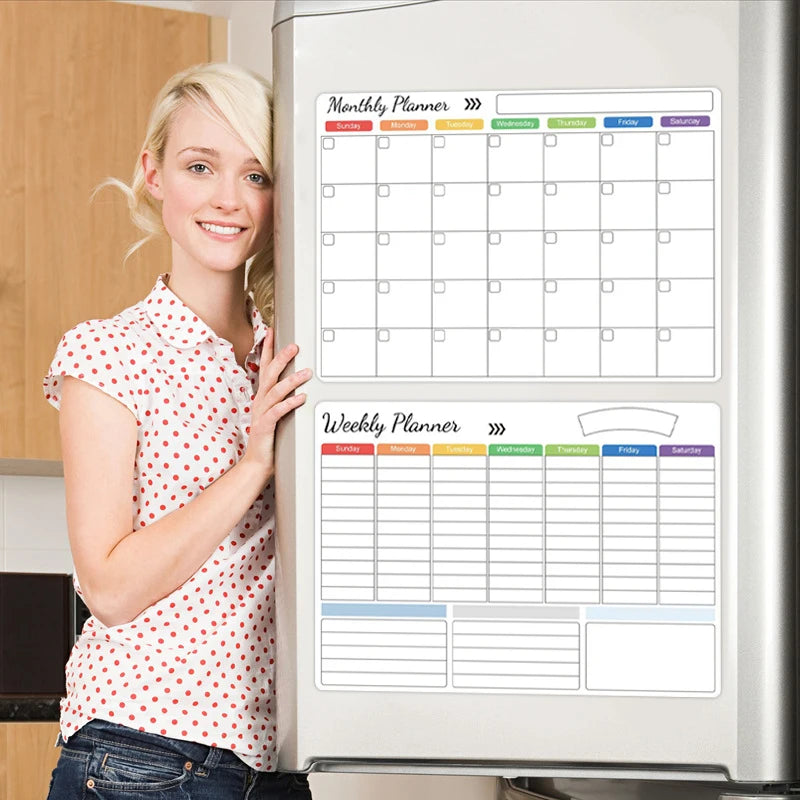 A woman stands next to a refrigerator displaying monthly and weekly planner grids on the door.