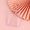 Clear acrylic card holder with a pink key ring displayed against a background of peach-colored paper