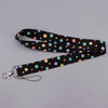 Black fabric lanyard with multi-colored polka dots, featuring a heart shape and attached to a key ring.