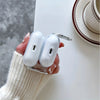 A hand holds a white TPU case for AirPods with a silver clasp, resting on a white surface.