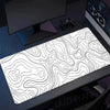 Black and white topographic map extended gaming mouse pad placed on a dark desk.