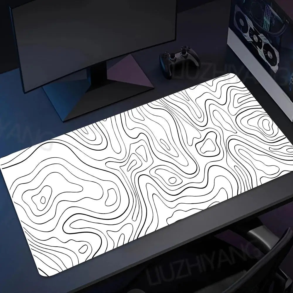 Black and white topographic map extended gaming mouse pad placed on a dark desk.