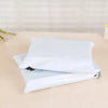 A stack of white self-sealing plastic mailing bags lying on a light surface.