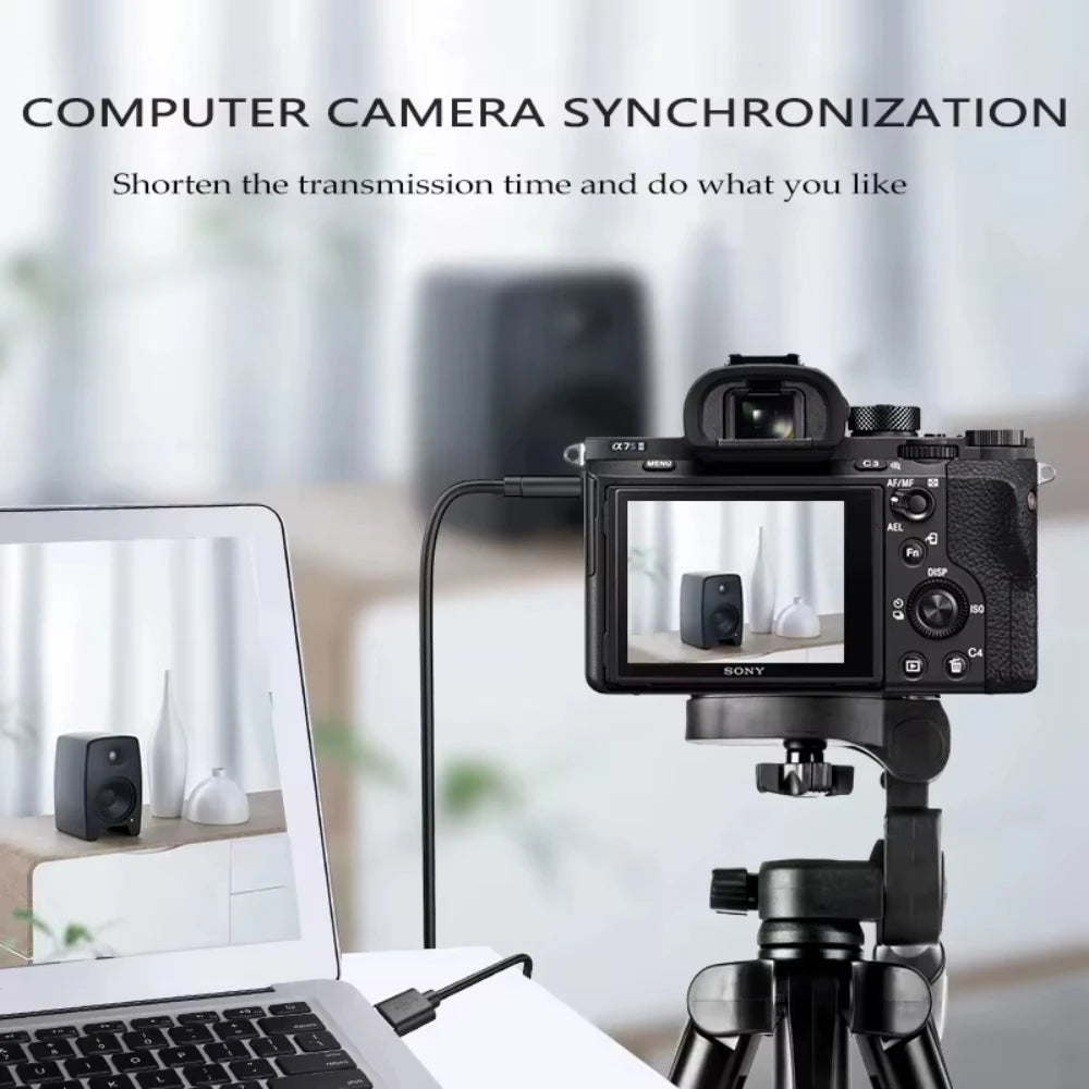A camera is set up on a tripod next to a laptop, demonstrating computer camera synchronization.