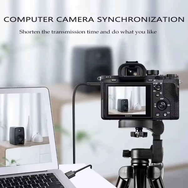 A camera is set up on a tripod next to a laptop, demonstrating computer camera synchronization.