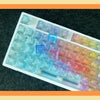 A close-up view of a white PC keycap set featuring colorful, translucent keycaps for a mechanical keyboard.