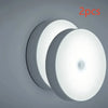Two round motion sensor LED night light discs shown against a gray background.