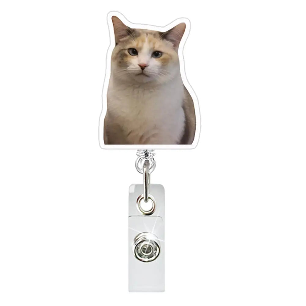 A light brown tabby cat is visible on a retractable ID badge holder with a crocodile clip.