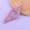 A pink resin thumb book stand rests on a light wooden cutting board.