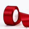A roll of vibrant red satin ribbon used for gift wrapping and DIY crafts.